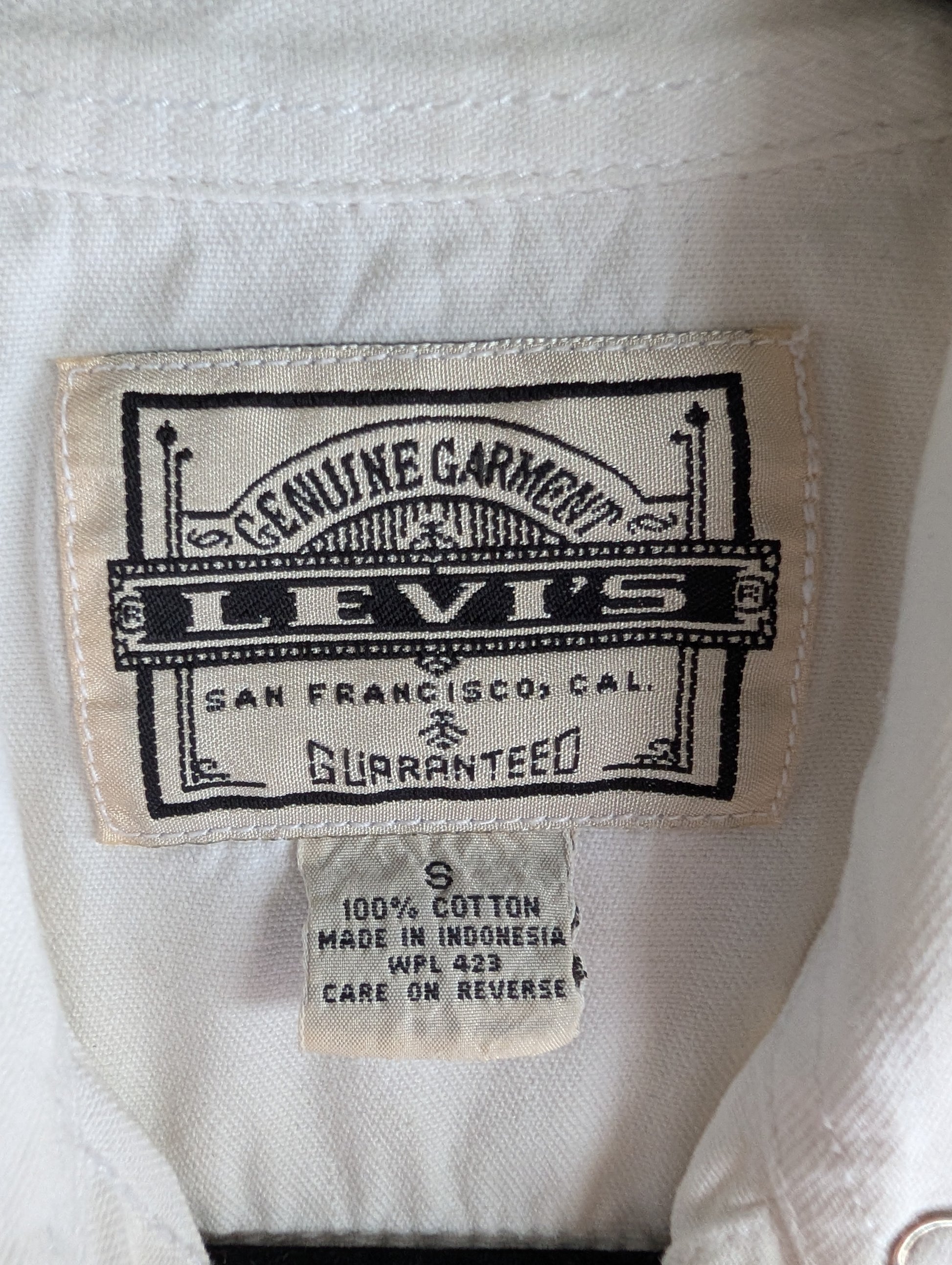 Levi's label on a white garment with 'Genuine Garment' and 'San Francisco, Cal.' text. Size Small. 100% cotton.