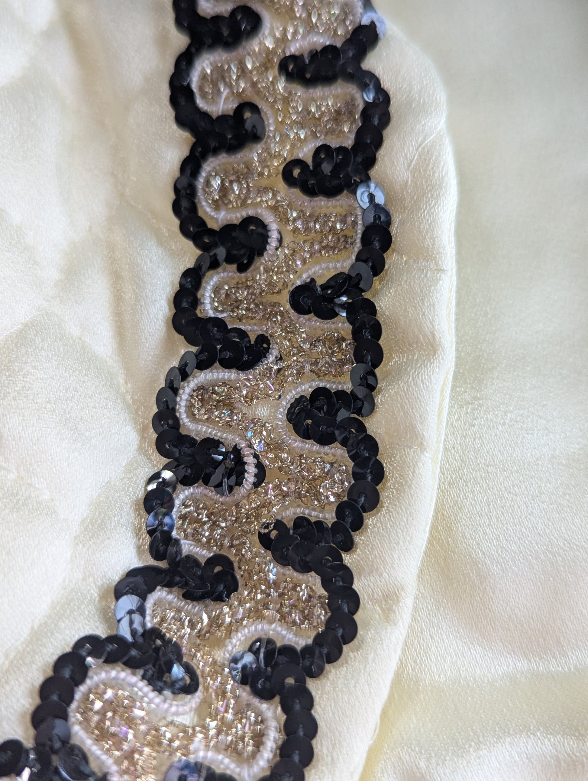 Black and gold sequin trim on an ivory quilted fabric 