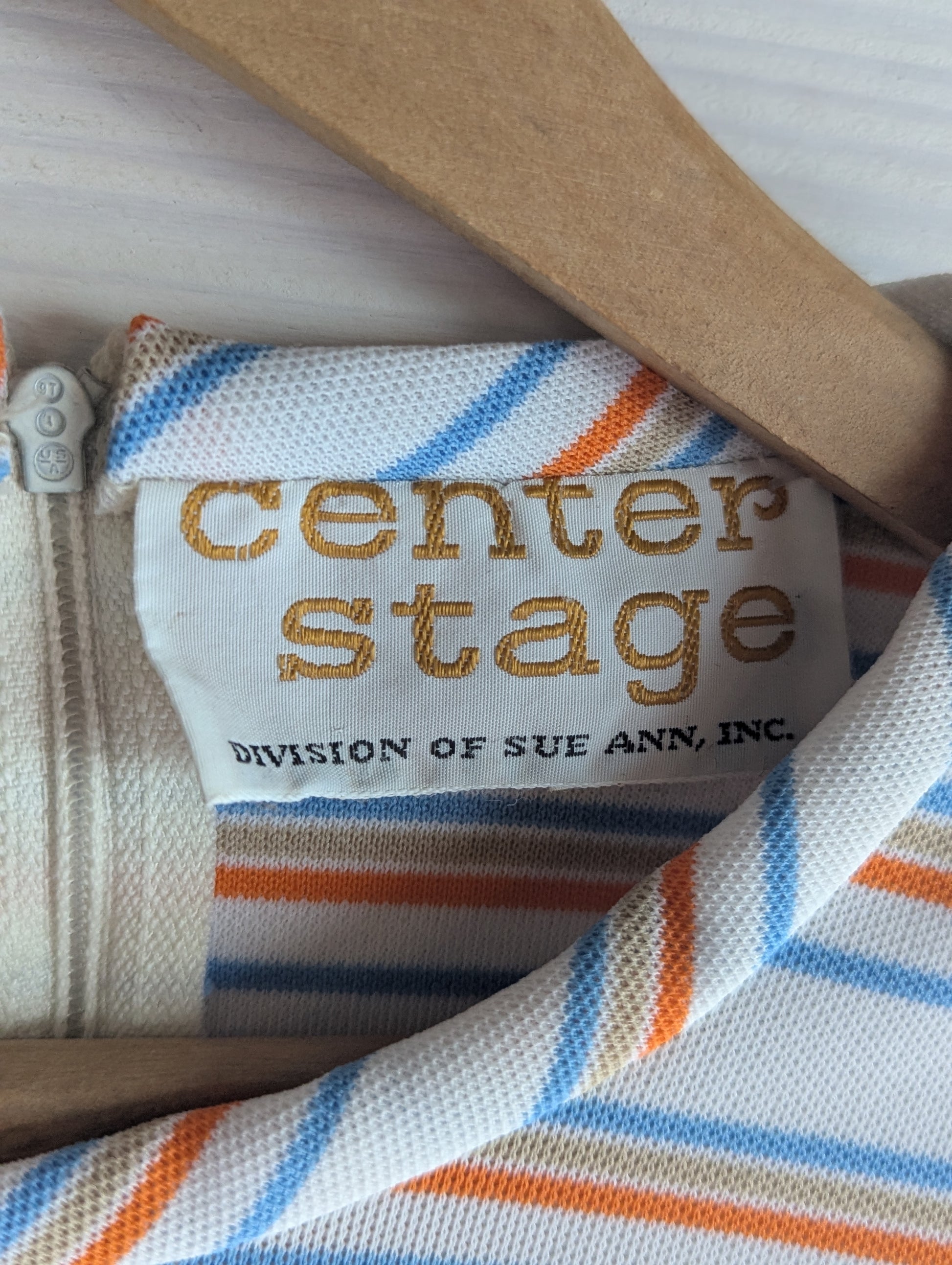 Close-up of a 'Center Stage' label on a garment with striped pattern.